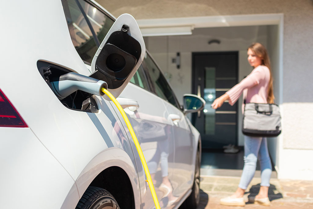 Person standing next to charging car